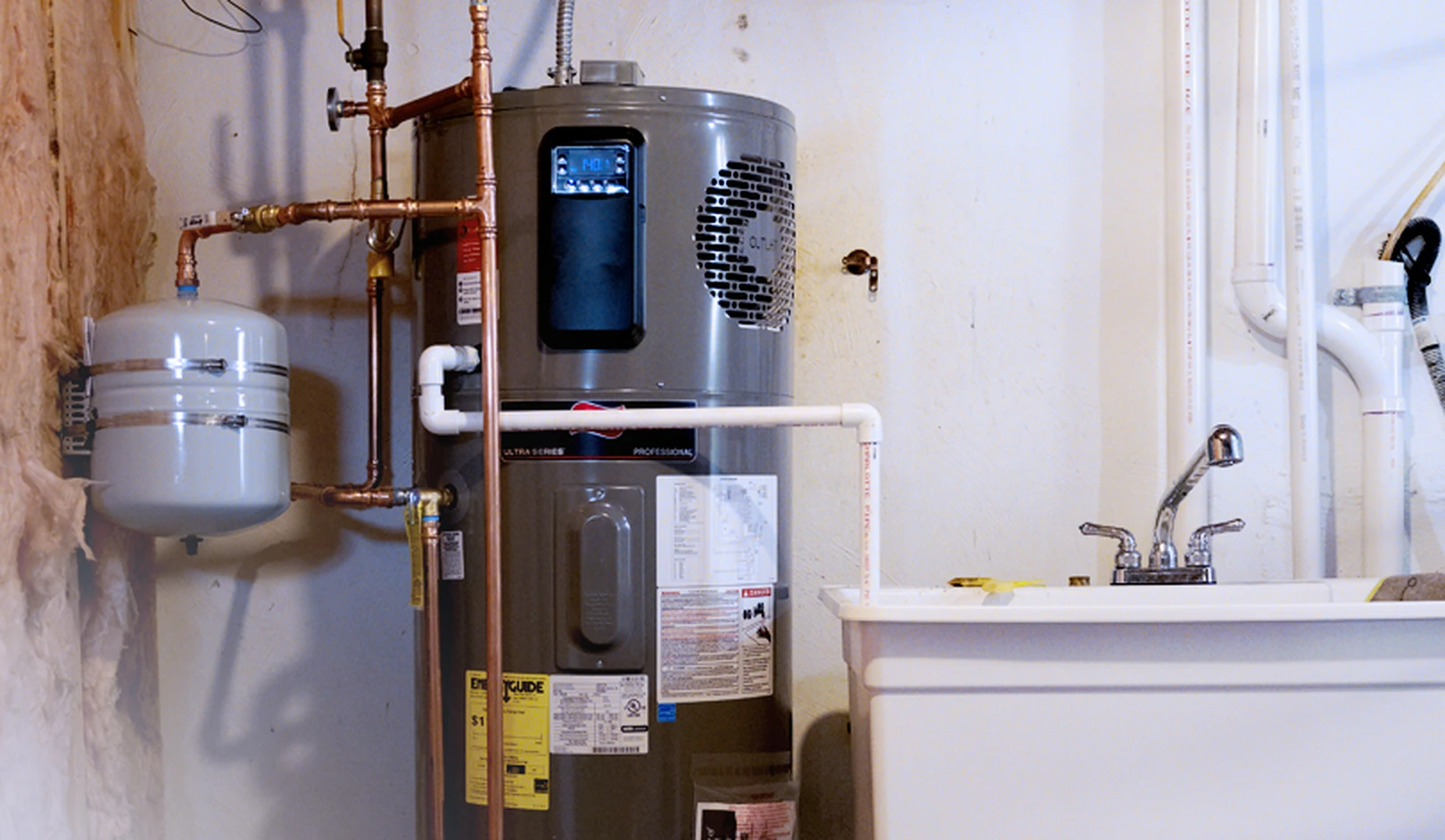 Utility room with water heater, expansion tank, copper piping, and bathroom sink with chrome faucet against white walls