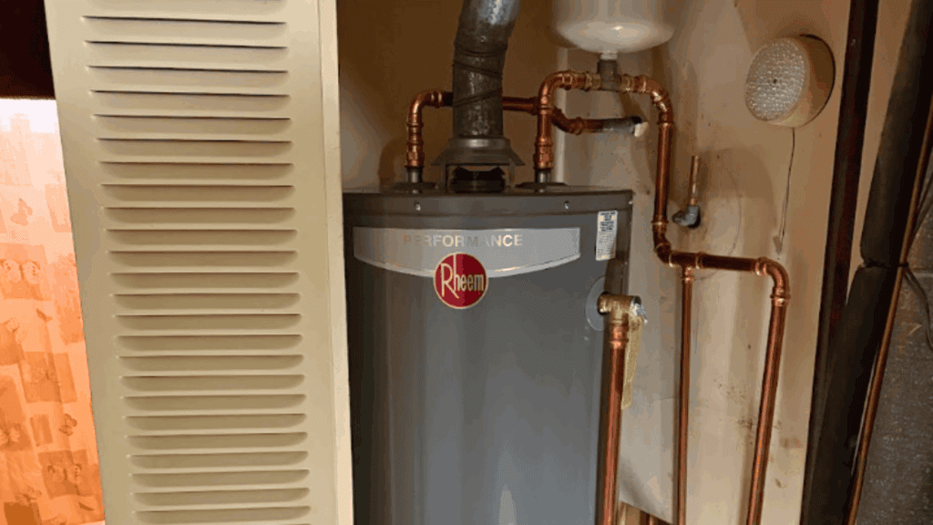 Rheem Performance tank water heater with copper piping and brass connections in a home utility room